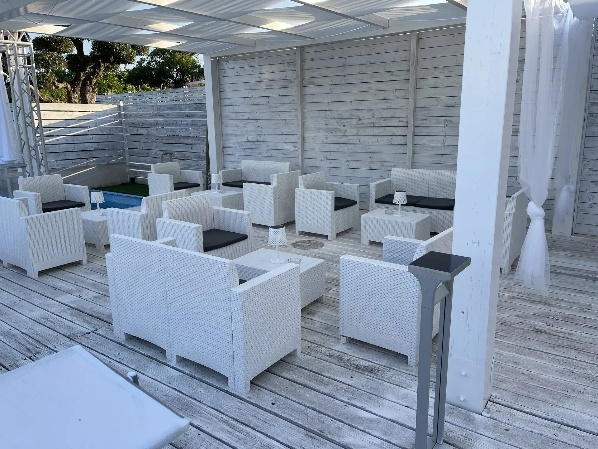 Zona lounge con pedana in legno e divani bianchi