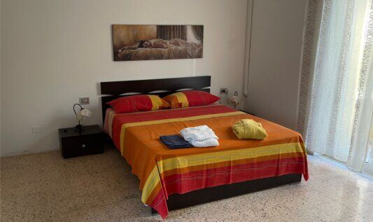 Camera matrimoniale con letto e copriletto nei toni caldi